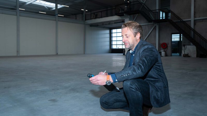 Een bedrijfshal wordt bekeken door een taxateur van Midden Nederland Makelaars